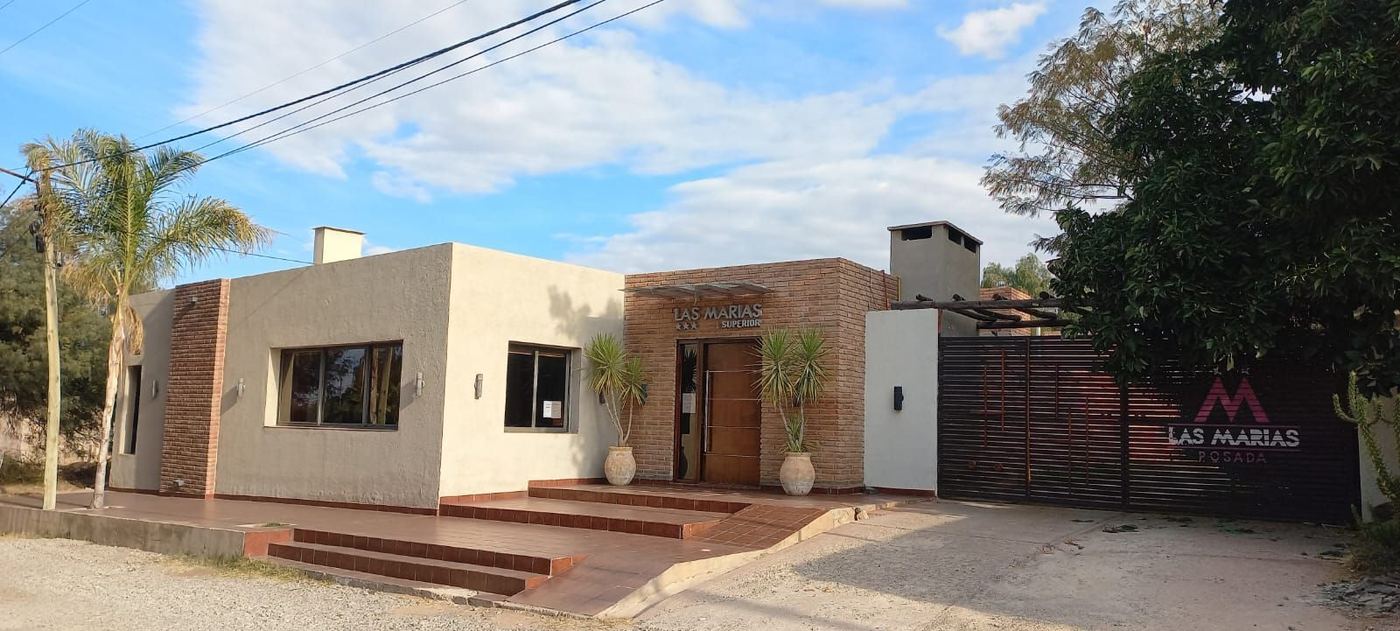 Fachada de Posada Las Marías de día, con entrada de ladrillo y portón